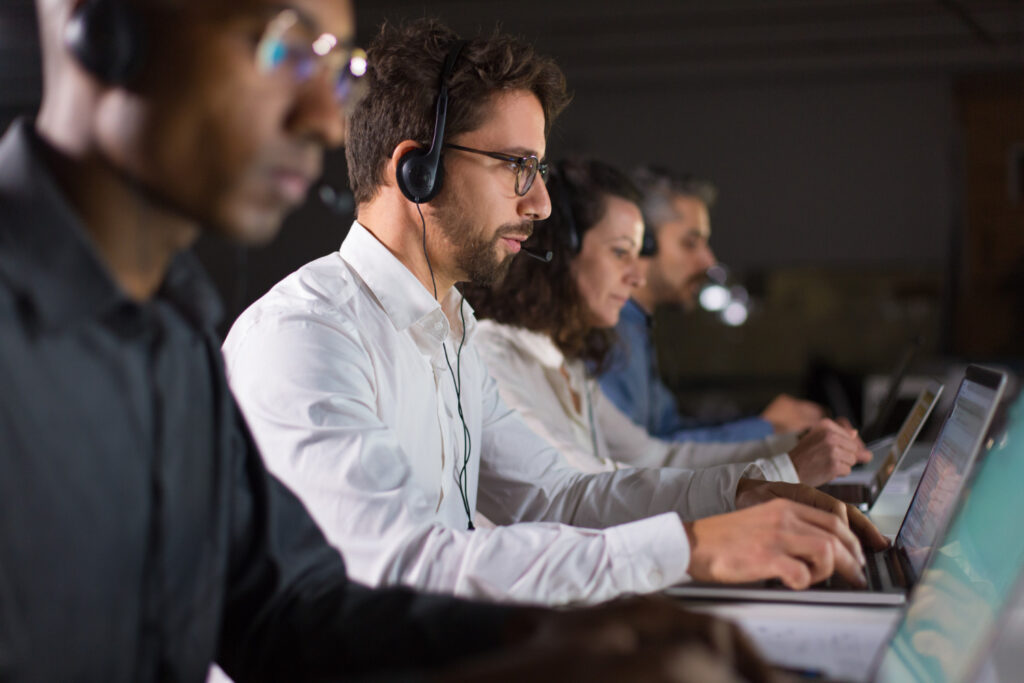 Uma mesa com vários operadores de atendimento ou de Call Center.